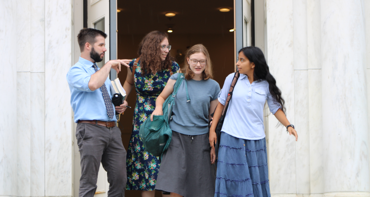 A tutor discusses Euclid with three students at the door of Palmer