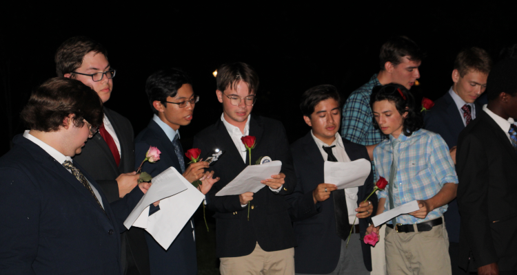 Men sing, suit-clad and with roses in hand