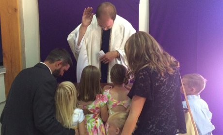 Fr. Mayer blesses the Minkel family