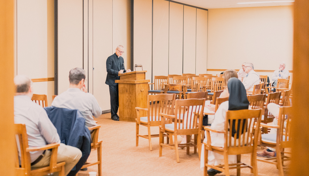 A priest gives an address in the Dillon Seminar Room