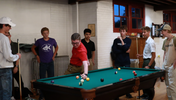 Playing pool: a student attempts the classic "behind-the-back" shot