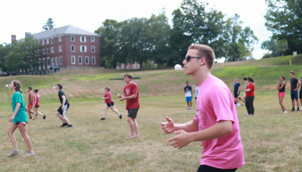 Students "race" across the field, each holding an egg in a spoon in their mouth