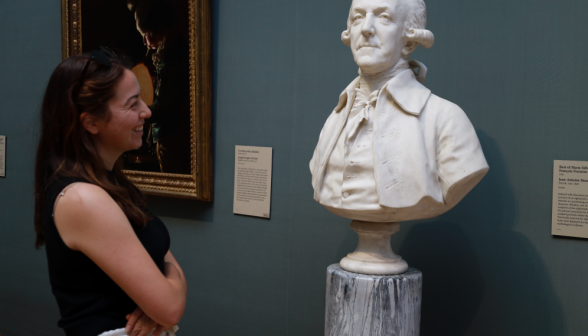 A student smiles as she admires a bust of Fontaine