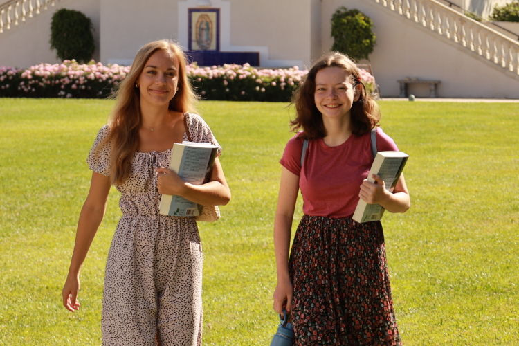 Two students walk across campus