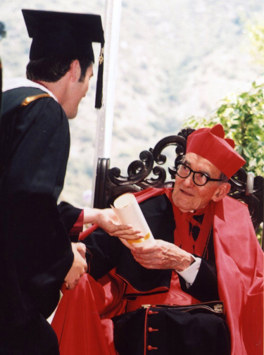 Cardinal Dulles gives presents a diploma to one of the graduates.