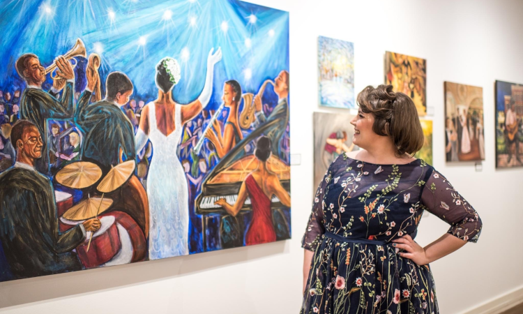 Kathryn Claahsen looks at one of her artworks on a wall