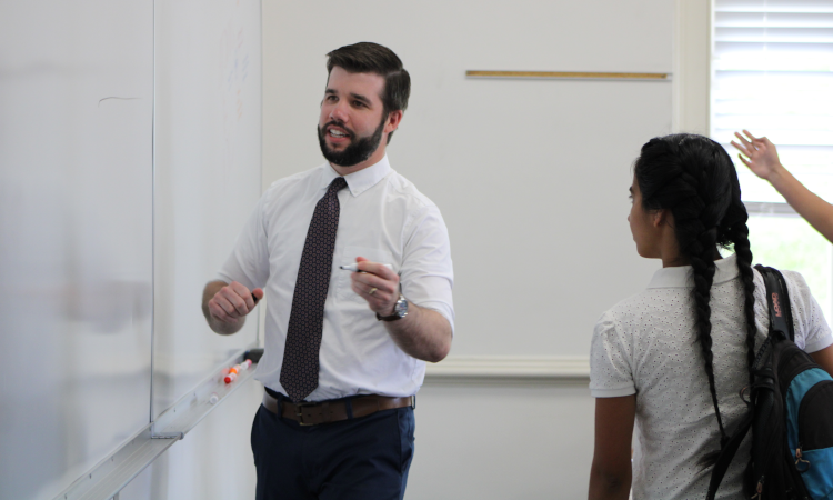 Tutor demonstrates for students on a white board