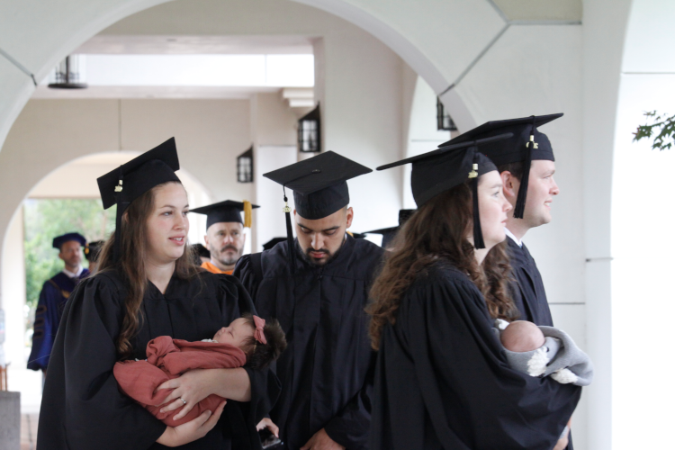Graduates process with newborn babies