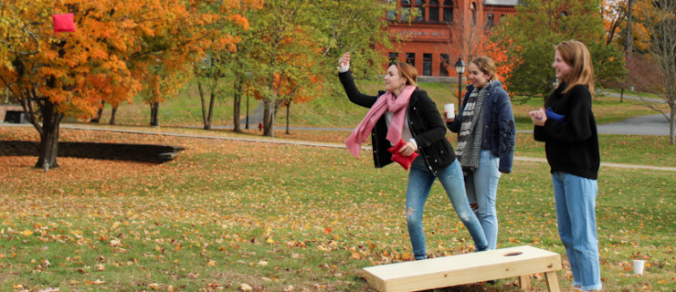 Students play cornhole on the New England campus