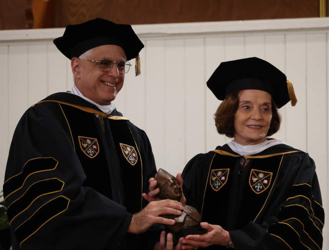 Michele D'Amour receives a bust of St. Albert the Great from Chairman of the Board of Governors Scott Turicchi