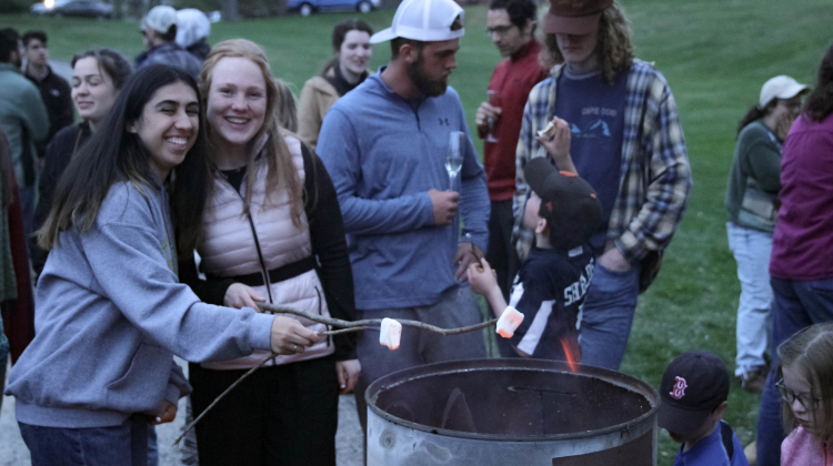 Students roast marshmallows over the ashes of the drafts