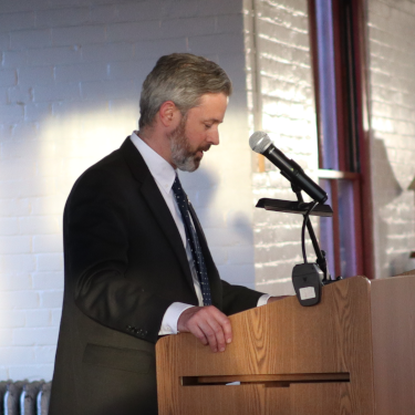 Dr. Gardner makes a speech at the podium in Tracy