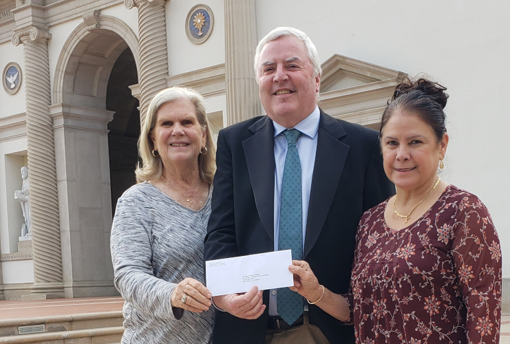 Cheryl Robinson and Maureen Rawlinson, trustees of the Fritz B. Burns Foundation, present a check to Dr. Paul J. O’Reilly, president of Thomas Aquinas College