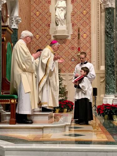 Fr. Hanley assists at a Mass