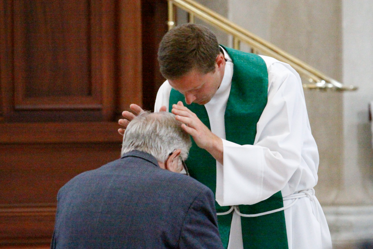 Fr. Masteller blesses President Michael F. McLean