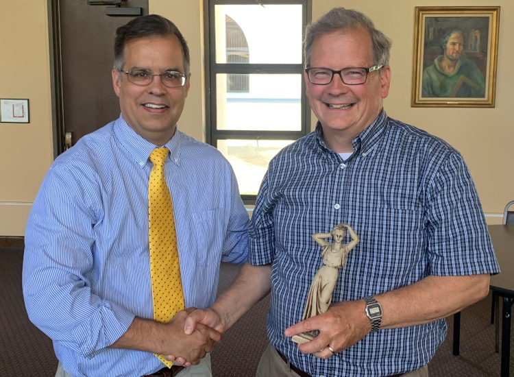 Dr. John J. Goyette, outgoing dean of the California campus, presents Dr. Sean Collins with a statue of “Lady Philosophy,” in honor of his teaching all 23 courses in the TAC curriculum.