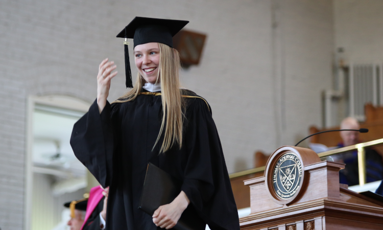 Mary Baker (’22) passes by the lectern that her class — aided by the Class of 1995 — presented to the College as a farewell gift.
