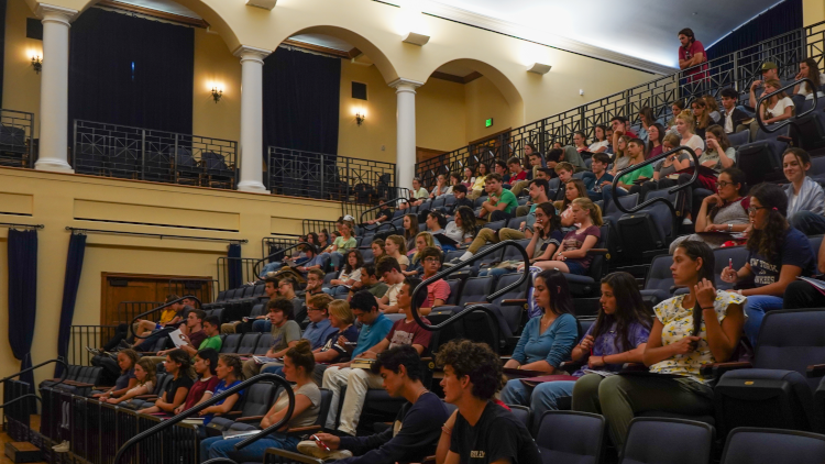 Students in St. Cecilia's auditorium seating, listening to Jon Daly's presentation