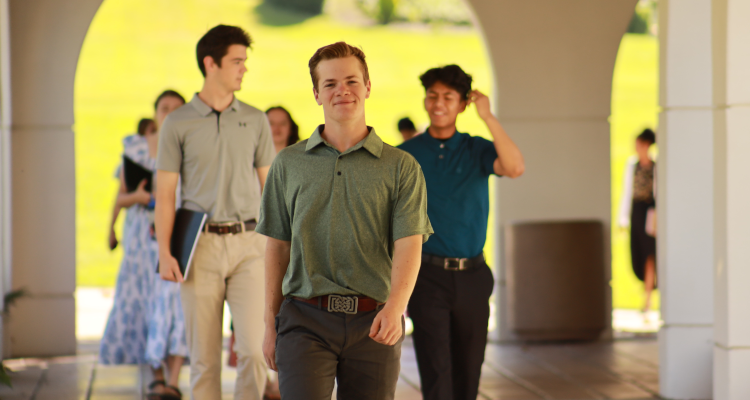 Happy students walk down the arcade