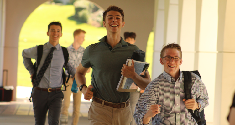 Students running alongside academic quadrangle