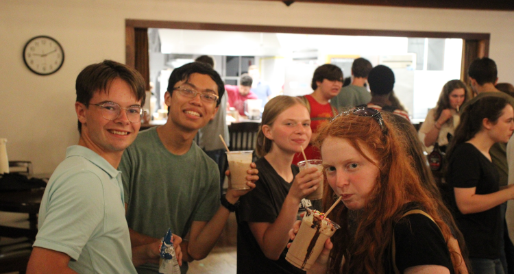 Four pose with milkshakes