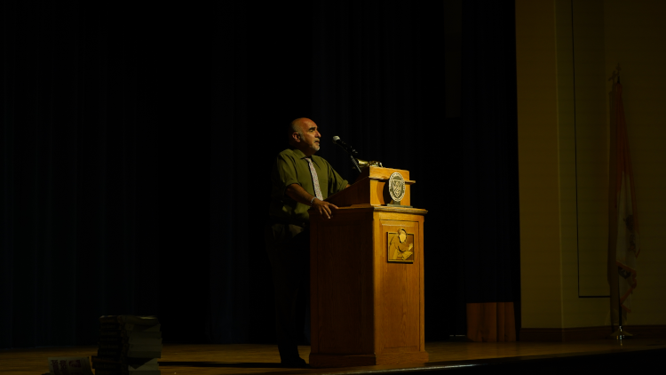 The spotlight is on Dr. Nieto as he lectures from the stage podium