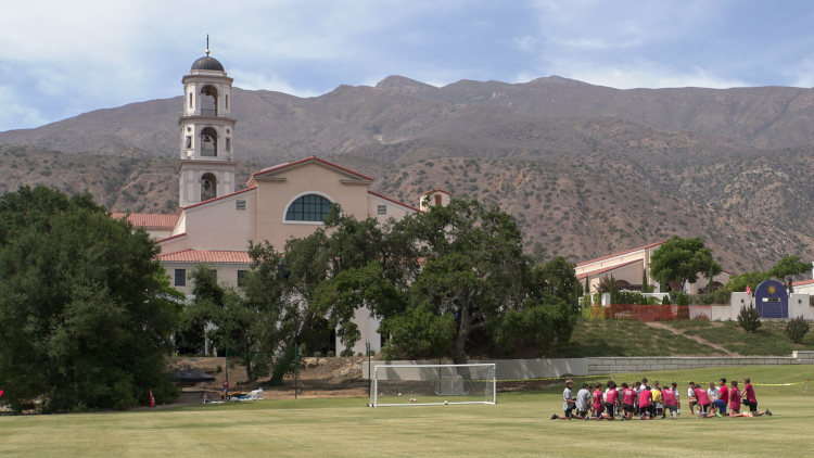 Students pray on the field pre-game