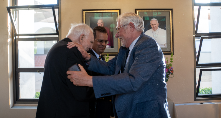 President Michael F. McLean welcomes retired TAC chaplain Rev. Cornelius M. Buckley, S.J., who made a surprise at the President’s Dinner to celebrate the Class of 2022