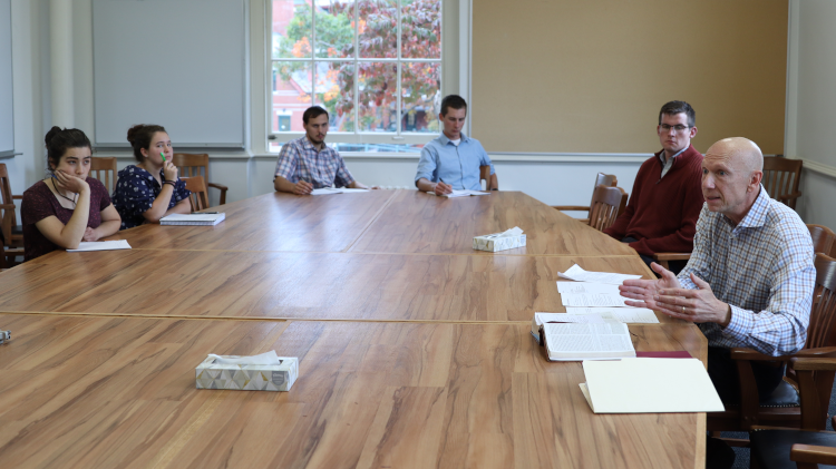 Rick Brajer addresses the students at a classroom table