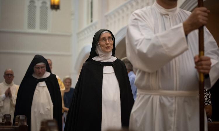 Sr. Maria Johanna Barrett processes in behind the crucifer