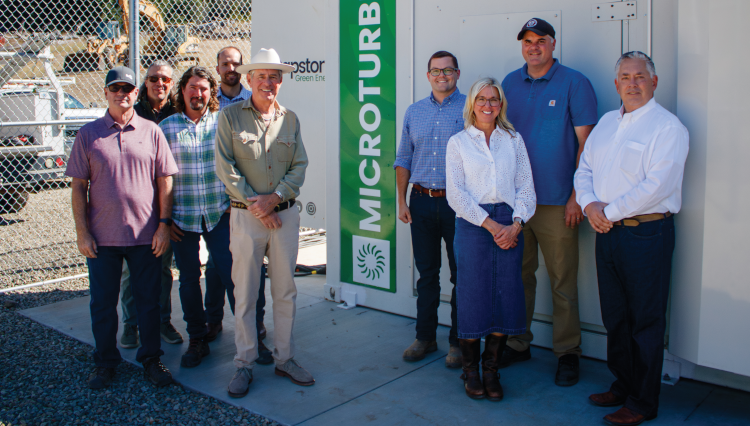 Officials from Carbon California, which has provided free natural gas and technical expertise, and Thomas Aquinas College, stand before the Capstone microturbines that now power the California campus.