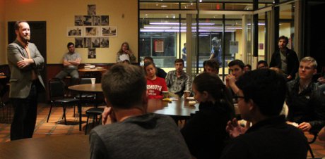 Dr. Christopher Decaen speaks to students in the campus coff