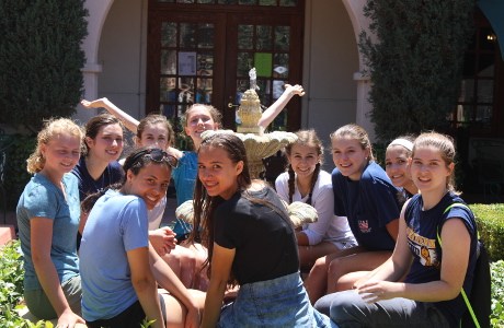 Students sitting on the fountain in Founders Plaza