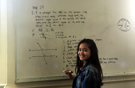 Student demonstrates prop on the whiteboard