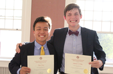 Two boys show off their Summer Program certificates