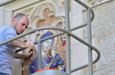 Michael Ferreira installs the mosaic above the chapel door.