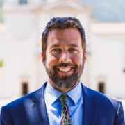 A well dressed man smiling at the camera.