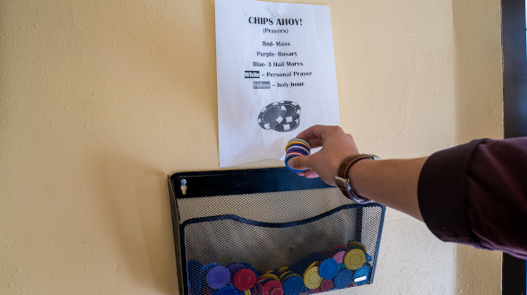 Student takes chip from prayer basket
