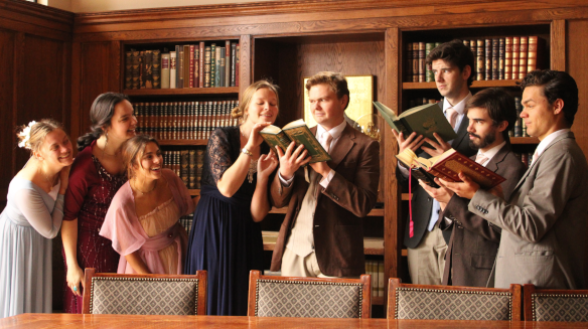 The eight main characters clustered around books