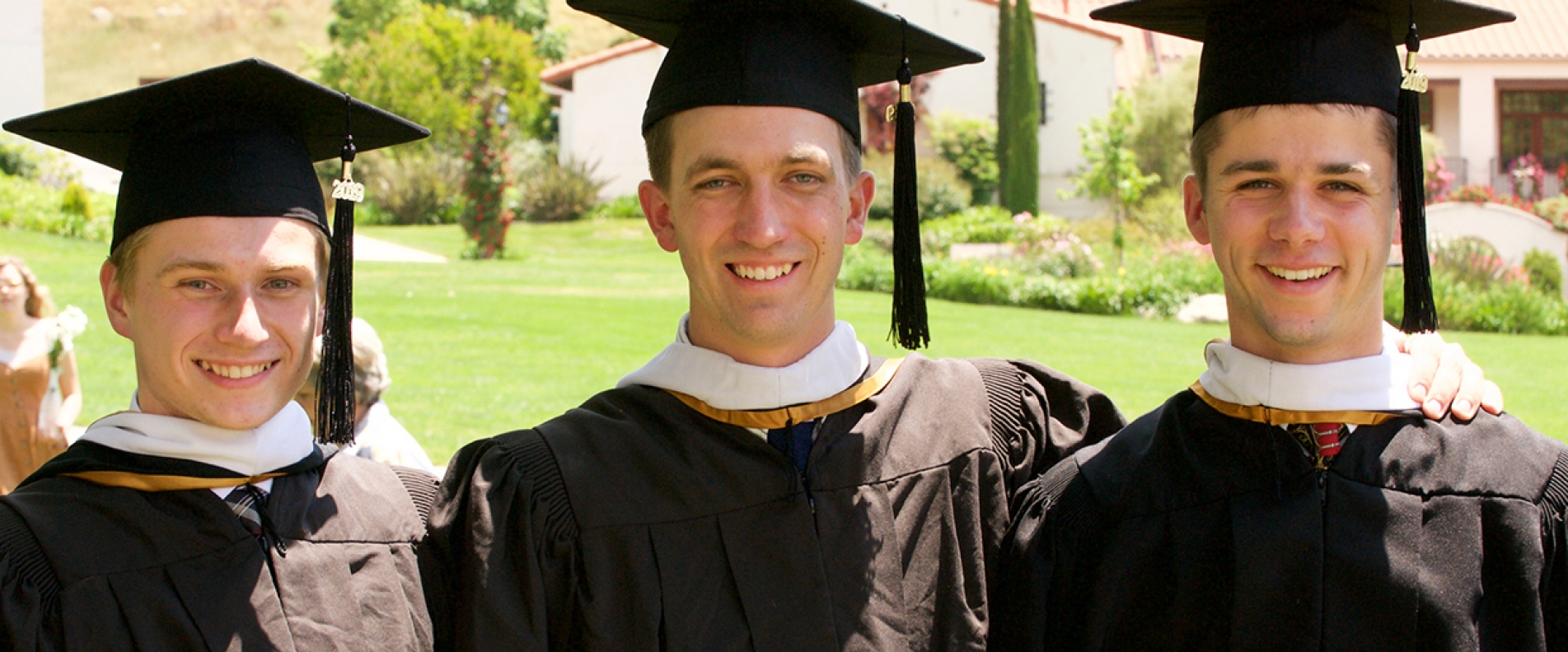 Three graduates at Commencement