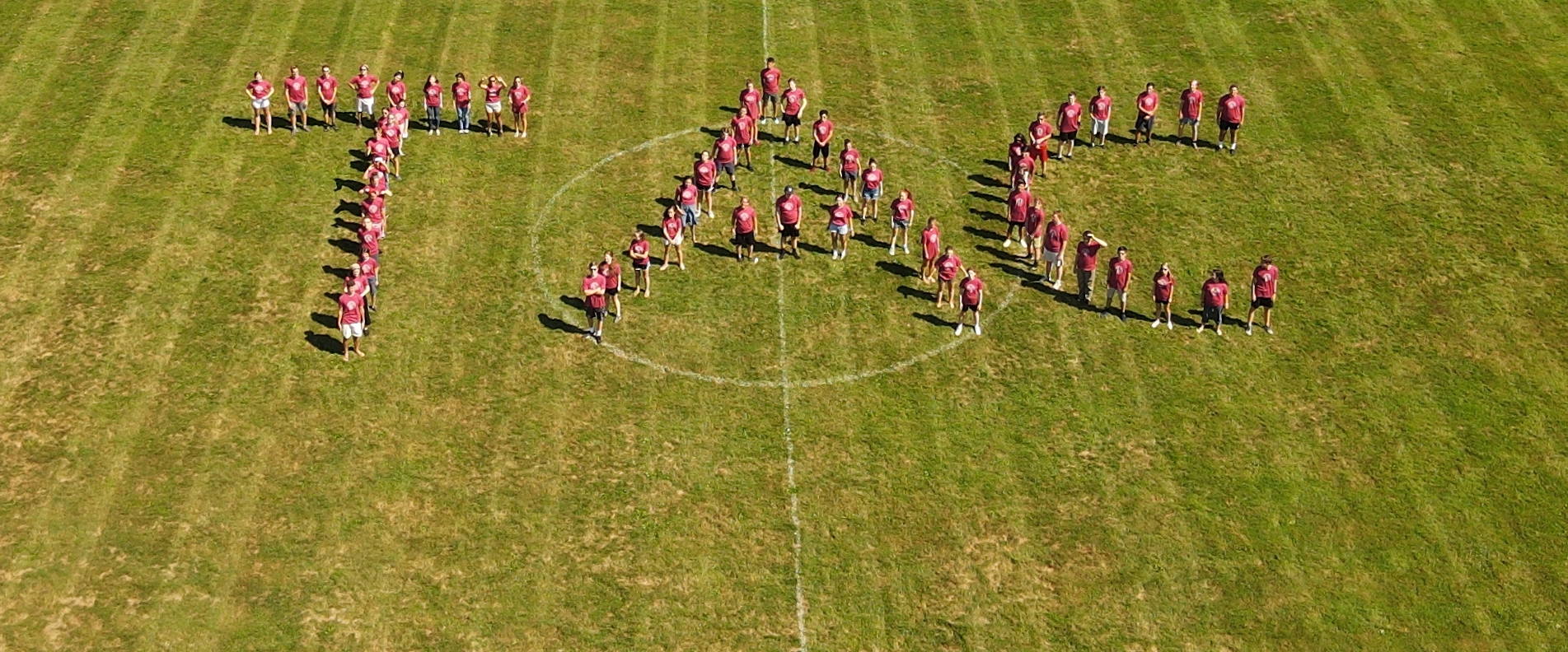 Students form the letters "T A C"