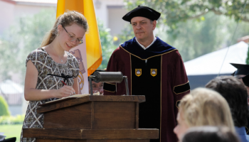 A student signs the register at Matriculation