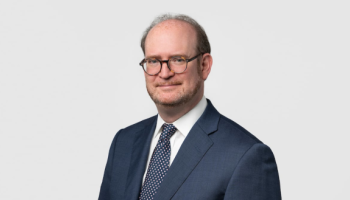 A smiling man in a suit and tie.