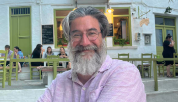 An older man with a beard and glasses smiling at the camera.