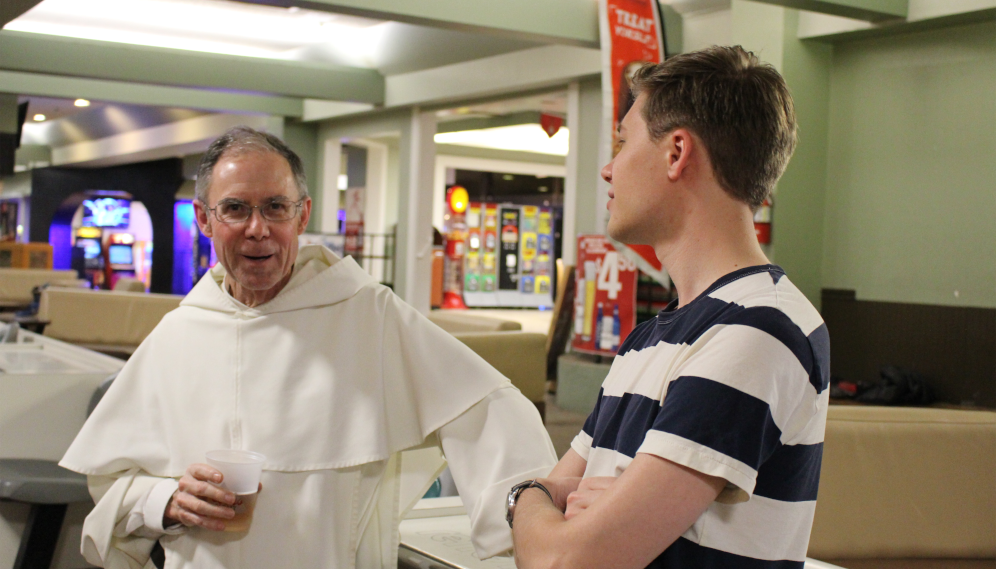 Fr. Paul chats with a senior at bowling night