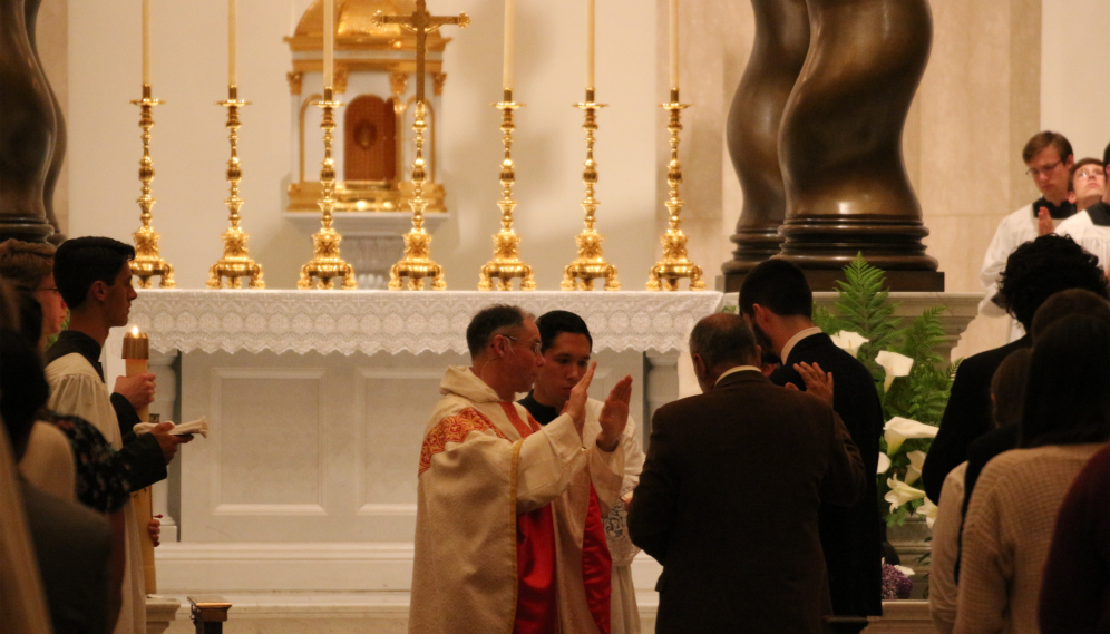 Fr. Paul administers Baptism and Confirmation to a student at the Easter Vigil Mass