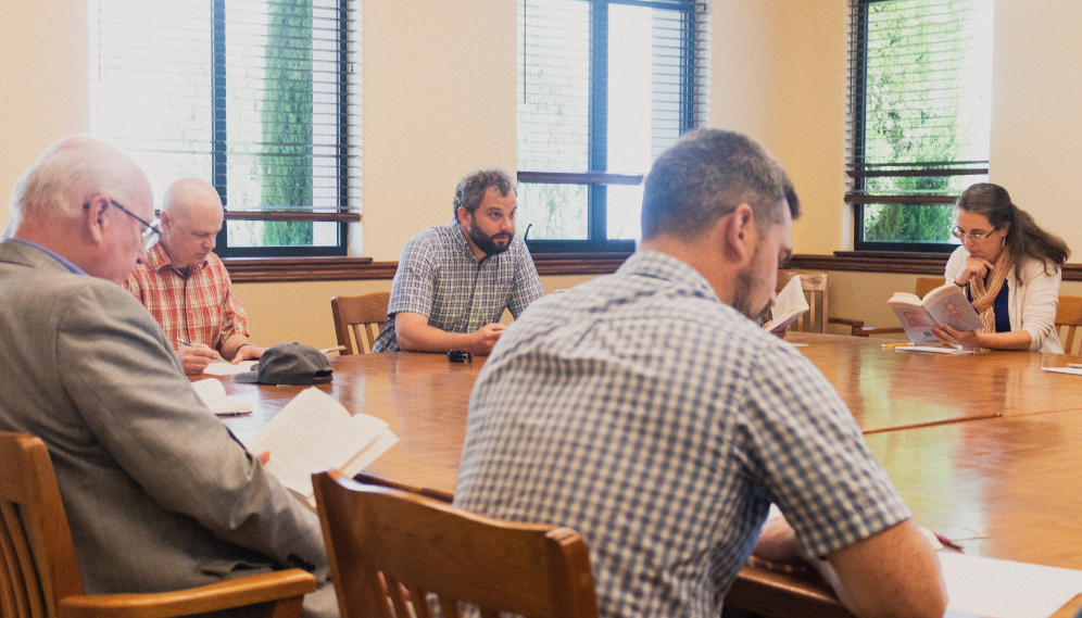 Tutors around the table read the text