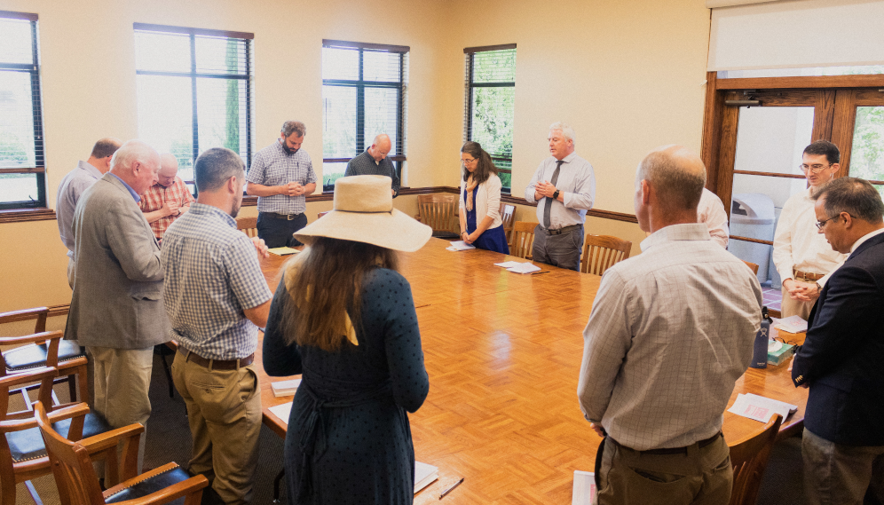 Tutors stand for the opening prayer