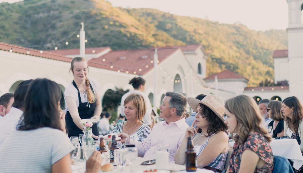 A server clears dishes from one table
