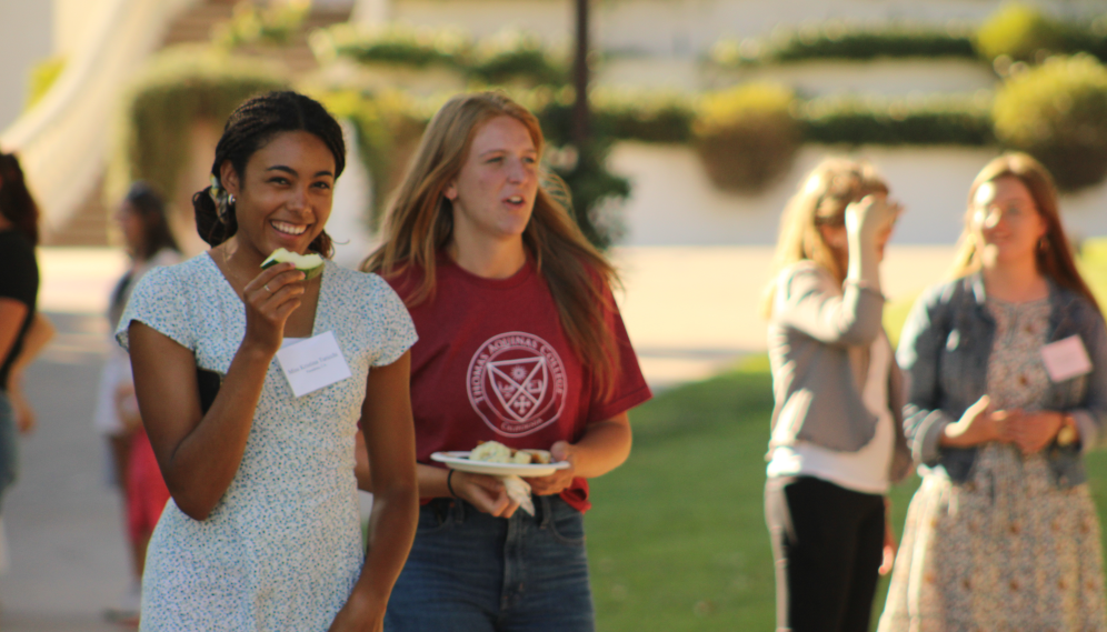 A student smiles for the camera, watermelon slice in hand
